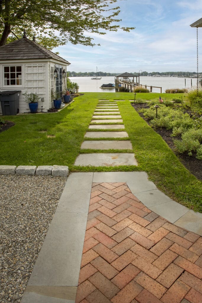 Curved stone walkway guiding guests through a garden-style landscape setting.